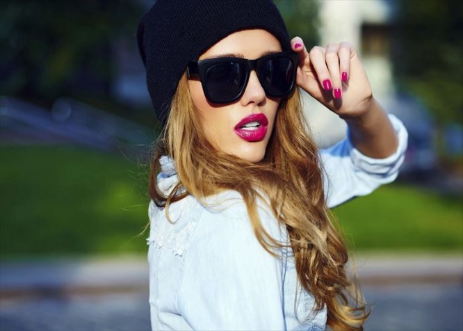 High fashion look.glamor lifestyle blond woman girl  model in casual jeans shorts cloth  outdoors in the street in black cap  in glasses