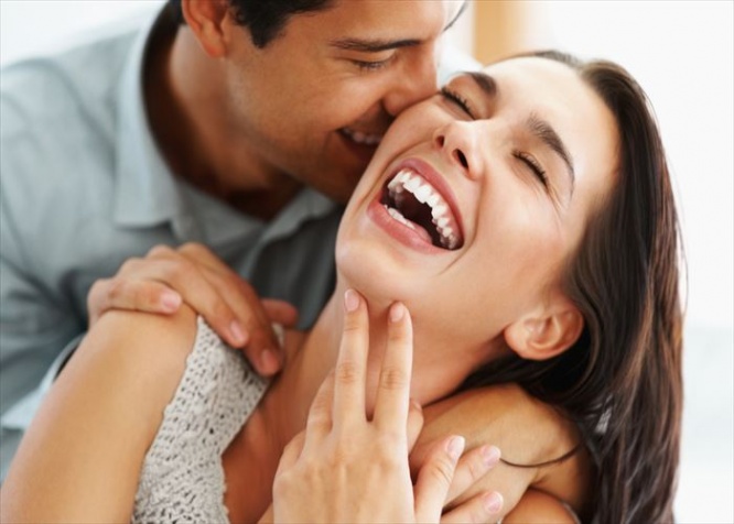 Closeup of beautiful young couple embracing and laughing