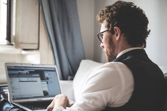 elegant attractive fashion hipster man using notebook