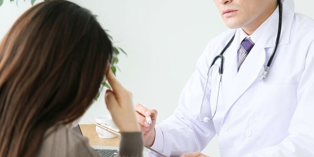 頭痛で診察を受ける女性