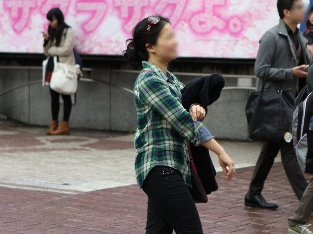 袖まくりをしながら歩く人