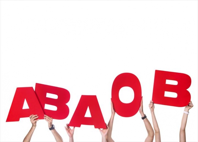 Group of people holding large blood group letters (education or medicine concept)