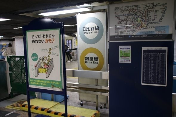 改札のわきに、機器や他の看板にはさまれて立っている