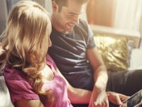 attractive couple using tablet together o nfuton h at home