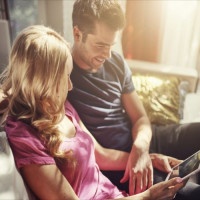 attractive couple using tablet together o nfuton h at home