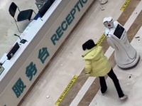 融通の利かない受付係のロボットにブチ切れ、ボコ殴りする女性