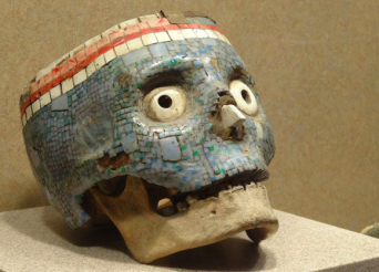 人間の頭蓋骨に宝石でモザイクが施されたアステカ族の宗教的装飾品