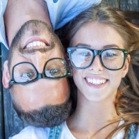 portrait of young couple lying on wooden bench