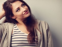 Thoughtful happy beautiful young woman holding the head and looking up. Vintage portrait