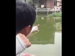 まさにスゴ技！　糸がついた針を指パチンコで飛ばして魚を釣り上げる男性。