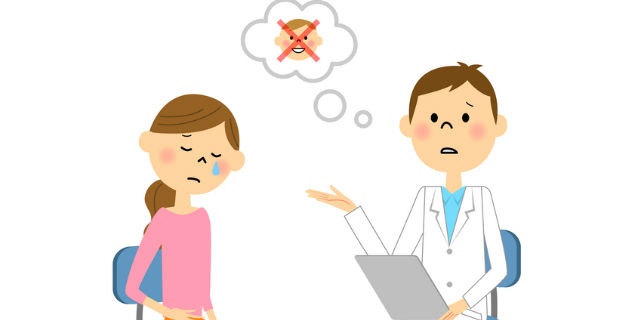 医師から流産を告げられる女性