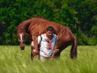 馬を背にのせユサユサ運ぶ。超人ハルク的存在感を持つ怪力男性の牧歌的光景(ウクライナ)