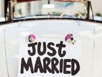 Close-up of "Just Married" sign attached on convertible car's trunk. Horizontal shot.