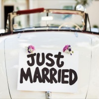 Close-up of "Just Married" sign attached on convertible car's trunk. Horizontal shot.