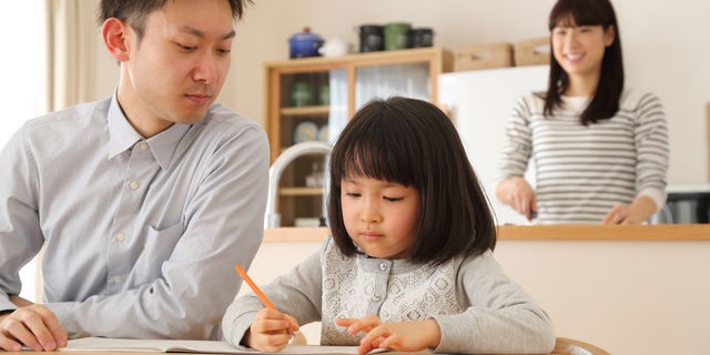 勉強を娘に教えるパパを見守るママ