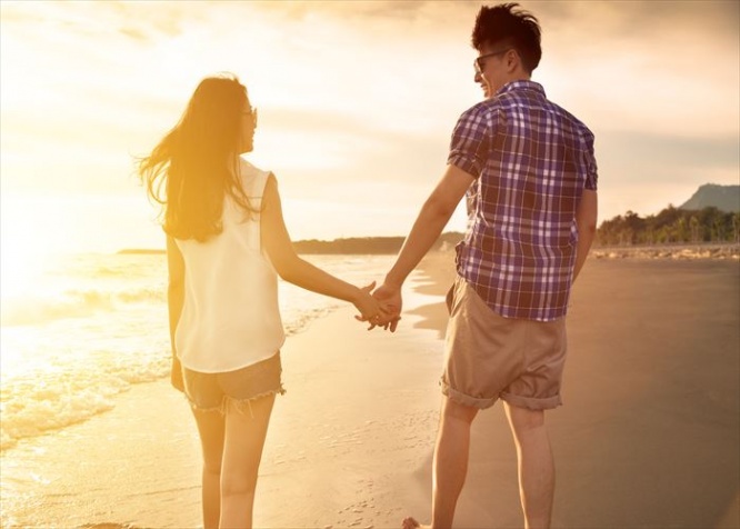 young couple enjoying a beach walk at sunset