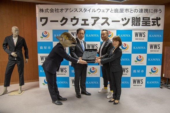 ワークウェアスーツ贈呈式(写真左から、かのやカンパチロウ、鹿屋市長・中西茂、オアシスライフスタイルグループ代表取締役・関谷有三、オアシススタイルウェア代表取締役・中村有沙、敬称略)