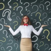 Business woman with question mark on a blackboard