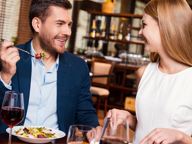 レストランで食事中のカップル