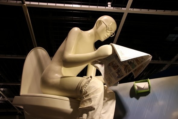 展示室のトイレで新聞を読むお父さん。今時の若者ならスマホ?