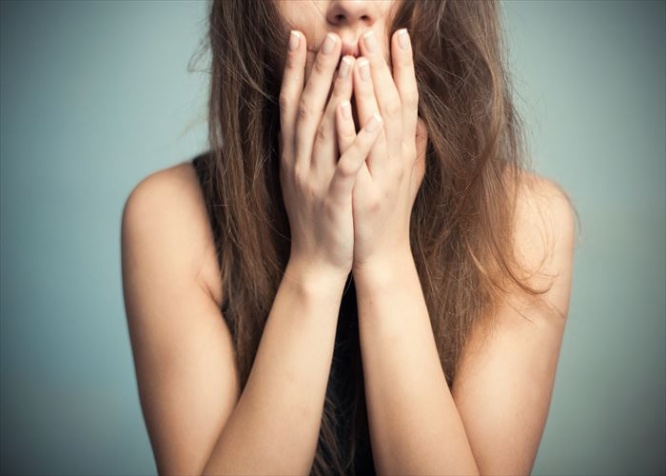 The woman touches finger-tips to the mouth